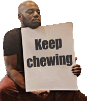 a man holding a sign that says " keep chewing "