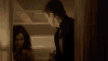 a man and woman are standing next to each other in a room .