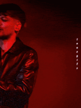 a man in a leather jacket sings into a microphone in front of a sign that says lou x gifs