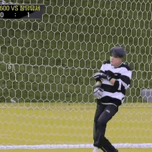 a soccer goalie is standing in front of a goal with a scoreboard behind him that says 600 vs 1