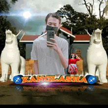 a man wearing a mask takes a selfie in front of a kanglasha sign