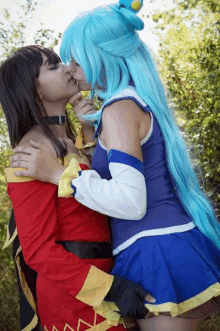 a woman with blue hair kisses another woman in a red and blue outfit