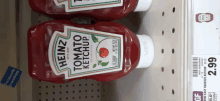 two bottles of heinz tomato ketchup are on a shelf