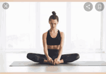 a woman is sitting on a yoga mat with her legs crossed and her feet crossed .