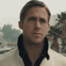 a close up of a man wearing a white jacket and a black shirt .