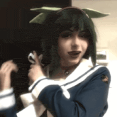 a girl with green hair is wearing a blue and white uniform