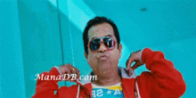 a man wearing sunglasses and a red jacket has manadb.com written on the bottom