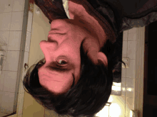 a man 's face is upside down in front of a bathroom door