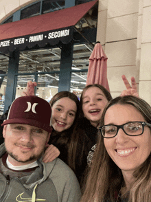 a family posing for a picture in front of a pizza beer panini secondi restaurant