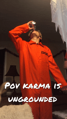 a man in an orange jumpsuit is drinking from a can with the words " pov karma is ungrounded " above him