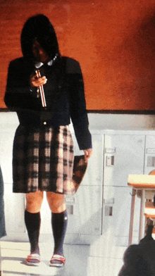 a girl in a plaid skirt is standing in front of a row of lockers with the letters ec on them