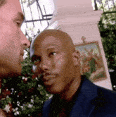 two men are looking at each other in a room .