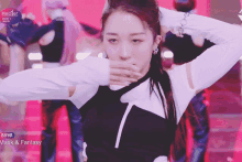 a woman in a black and white outfit is dancing in front of a screen that says mask & fantasy