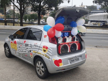 a silver car with balloons in the trunk and the license plate dhw-7699