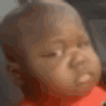 a close up of a baby 's face with a blurry background .