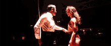 a man and a woman are dancing on a stage .