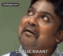 a man is making a funny face and asking garlic naan .