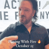 a man in a black shirt is playing with fire october 25