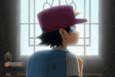 a boy wearing a red hat looks out a window