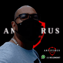 a man wearing glasses and a black face mask stands in front of a poster for antivirus