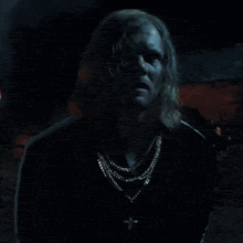 a man with a cross around his neck is screaming