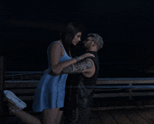 a man with a tattoo on his arm is kissing a woman