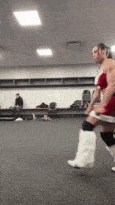 a man in a santa claus outfit is running in a room