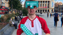 a man wearing a minecraft helmet and holding a diamond sword is making a funny face .