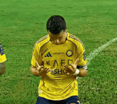 a soccer player wearing a yellow shirt that says kaed sho on it