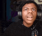 a man wearing headphones is making a funny face while looking at the camera .