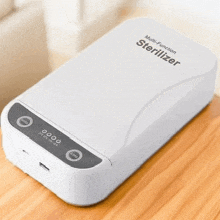 a white box that says multi-function sterilizer on it is sitting on a wooden table .