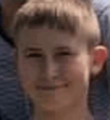 a close up of a young boy 's face with a blurred background .