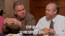 two men are sitting at a table eating hamburgers and one of them says stop being so pretendious kyle