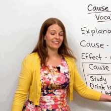 a woman in a yellow cardigan is standing in front of a white board with the word cause written on it