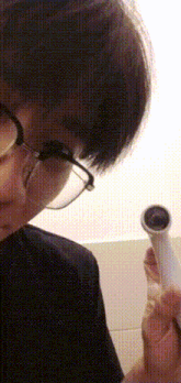 a close up of a person wearing glasses and holding a hose .