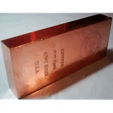 a copper bar is sitting on top of a white surface .