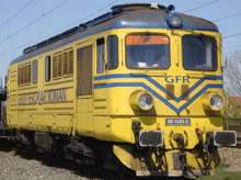 a yellow and blue train that says gfr on the front