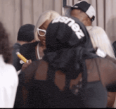 a woman wearing a black shirt that says zeus on the back
