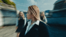 a blurry picture of a woman in a suit walking