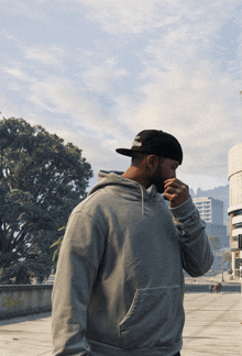 a man wearing a grey hoodie and a black hat with the word snoop on it