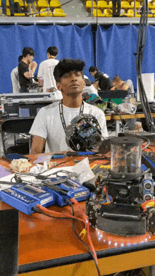 a man sitting at a table with a robot on it and a charger that says ' lithium ion ' on it