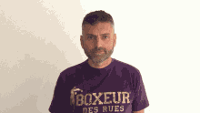 a man wearing a purple boxeur des rues t-shirt