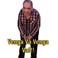 a man in a plaid shirt is holding a bottle in his hand and says `` venga va venga va ! ''