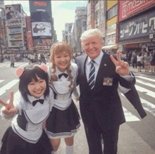 a man in a suit and tie poses for a picture with two girls