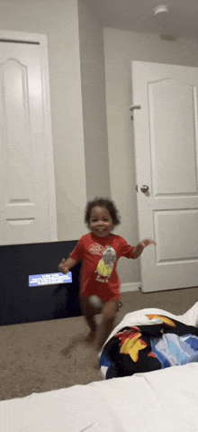 a little girl in a red shirt is running in front of a sign that says ' united states of america ' on it