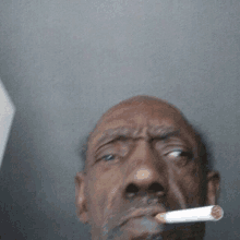 a man with a cigarette in his mouth looks serious