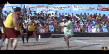 a group of men are playing a game of volleyball in front of a crowd with a sign that says sea coal service