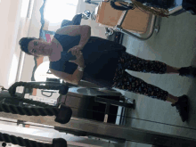 a woman is taking a picture of herself in a gym mirror