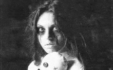 a black and white photo of a ghost holding a teddy bear .