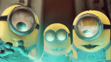 three yellow minions wearing goggles are standing next to each other and looking at the camera
